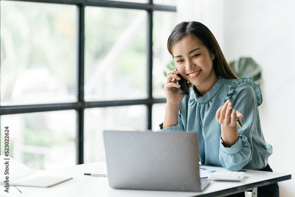 Asian businesswoman in formal suit in office happy and cheerful during using smartphone and working. Asian businesswoman in formal suit in office happy and cheerful during using smartphone and working.
