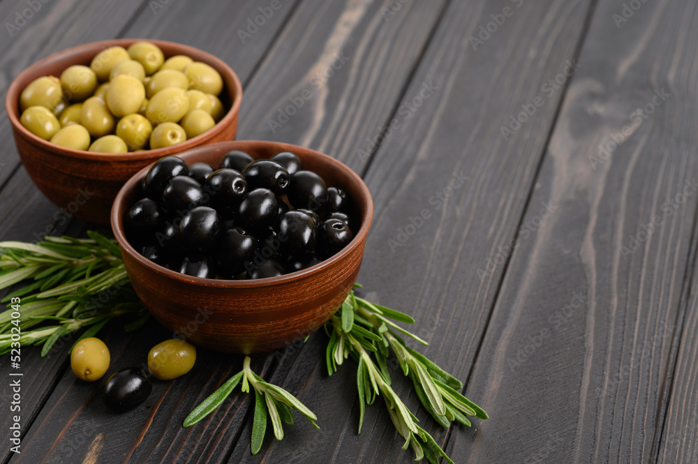 Black and green olives on a dark wooden rustic background. Black and green olives on a dark wooden rustic background.