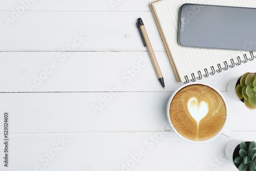 Workplace, Flat lay with blank copy space. Top view above of white wood office desk table with notebook, smartphone, and a cup of coffee. Business, and technology concept.