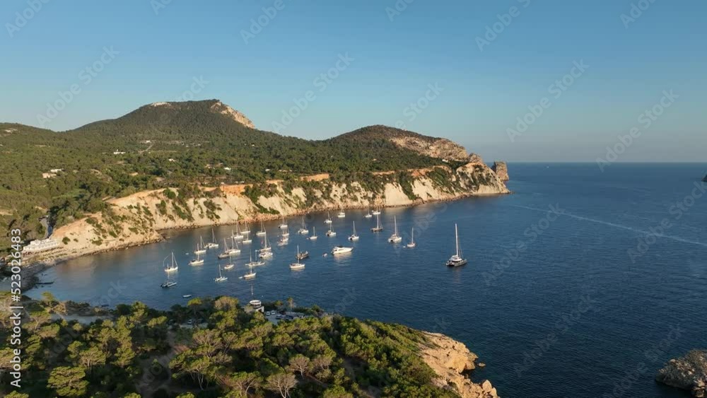 Aerial video of Es Vedra and Es Vedranell islands, in front of a beach full of boats and yachts. Aerial video of Es Vedra and Es Vedranell islands, in front of a beach full of boats and yachts.