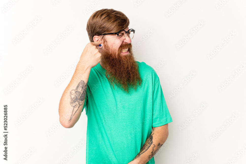 Young caucasian red-haired man isolated on white background covering ears with hands. Young caucasian red-haired man isolated on white background covering ears with hands.
