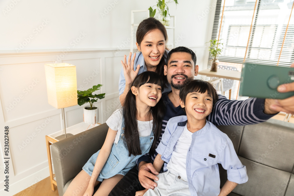 Asian family using tablet, laptop, phone for playing game or movies, relaxing at home for technology lifestyle concept. Asian family using tablet, laptop, phone for playing game or movies, relaxing at home for technology lifestyle concept.