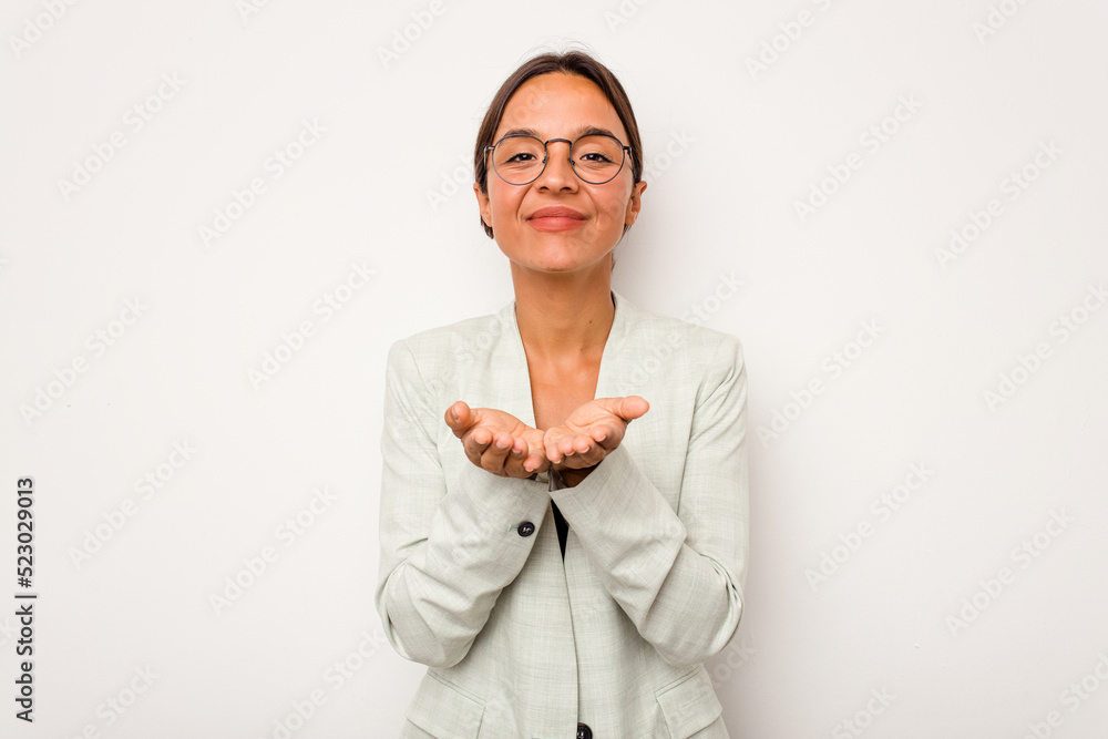 Young hispanic woman isolated on white background holding something with palms, offering to camera. Young hispanic woman isolated on white background holding something with palms, offering to camera.