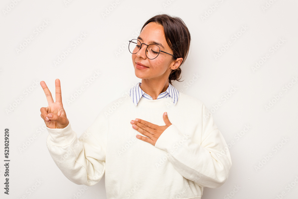 Young hispanic woman isolated on white background taking an oath, putting hand on chest. Young hispanic woman isolated on white background taking an oath, putting hand on chest.