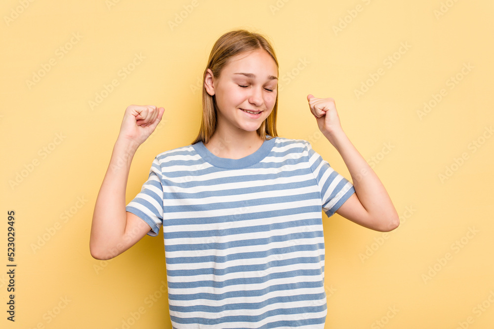 Young caucasian girl isolated on yellow background celebrating a victory, passion and enthusiasm, happy expression. Young caucasian girl isolated on yellow background celebrating a victory, passion and enthusiasm, happy expression.