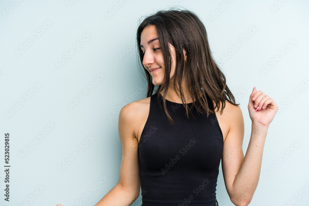 Young caucasian woman isolated on blue background dancing and having fun. Young caucasian woman isolated on blue background dancing and having fun.
