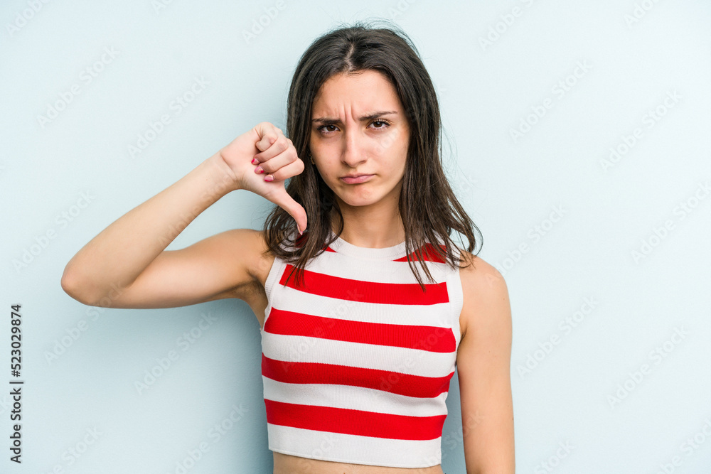 Young caucasian woman isolated on blue background showing thumb down, disappointment concept. Young caucasian woman isolated on blue background showing thumb down, disappointment concept.