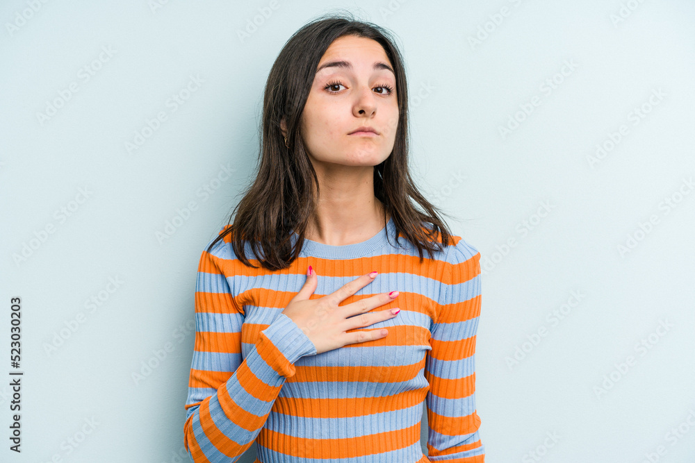 Young caucasian woman isolated on blue background taking an oath, putting hand on chest. Young caucasian woman isolated on blue background taking an oath, putting hand on chest.