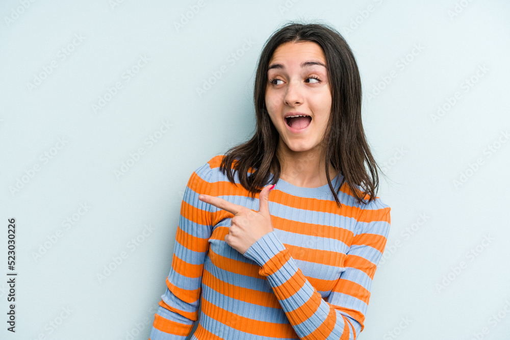 Young caucasian woman isolated on blue background looks aside smiling, cheerful and pleasant. Young caucasian woman isolated on blue background looks aside smiling, cheerful and pleasant.