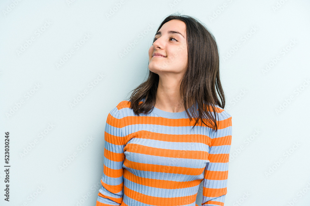Young caucasian woman isolated on blue background relaxed and happy laughing, neck stretched showing teeth. Young caucasian woman isolated on blue background relaxed and happy laughing, neck stretched showing teeth.