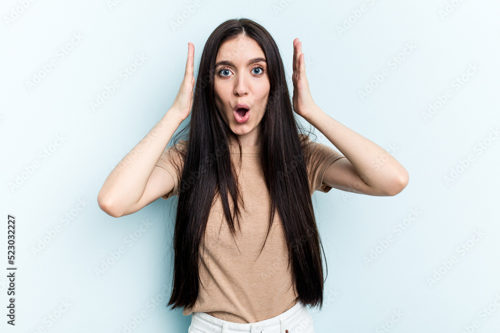 Young caucasian woman isolated on blue background surprised and shocked. Young caucasian woman isolated on blue background surprised and shocked.