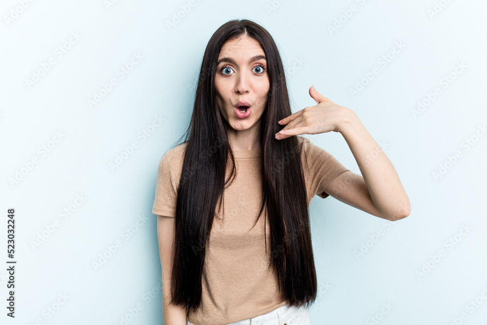 Young caucasian woman isolated on blue background laughing about something, covering mouth with hands. Young caucasian woman isolated on blue background laughing about something, covering mouth with hands.