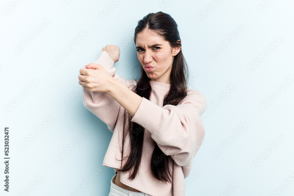 Young caucasian woman isolated on blue background having a neck pain due to stress, massaging and touching it with hand. Young caucasian woman isolated on blue background having a neck pain due to stress, massaging and touching it with hand.