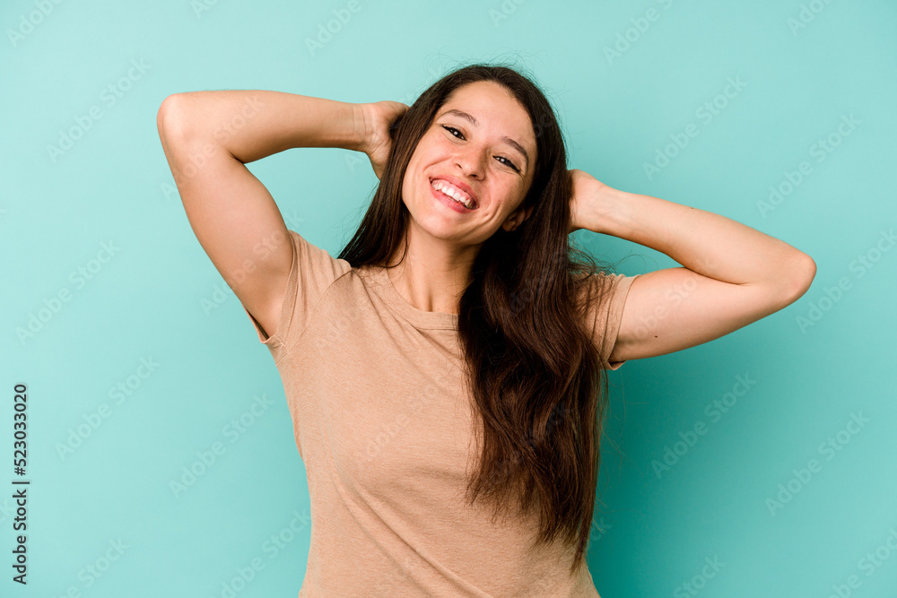 Fototapeta premium Young caucasian woman isolated on blue background stretching arms, relaxed position.