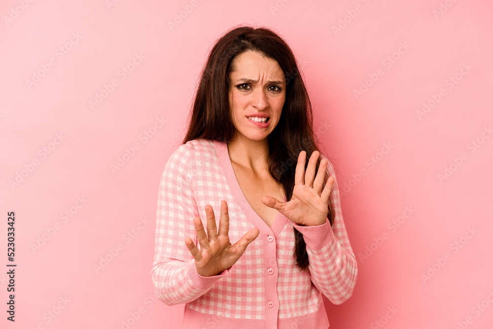 Young caucasian woman isolated on pink background rejecting someone showing a gesture of disgust. Young caucasian woman isolated on pink background rejecting someone showing a gesture of disgust.