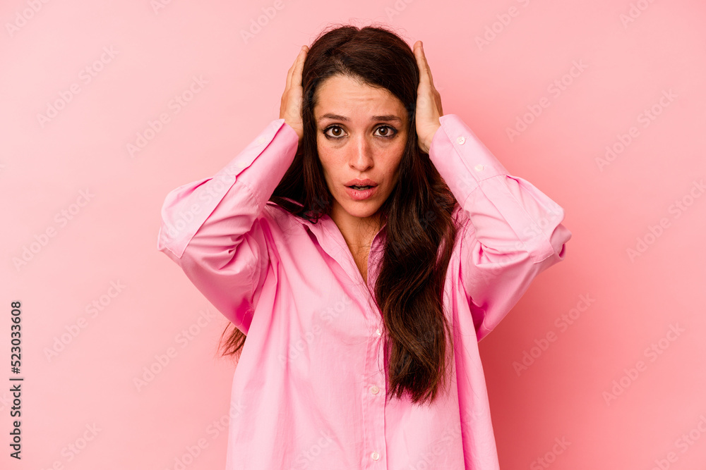 Young caucasian woman isolated on pink background covering ears with hands trying not to hear too loud sound. Young caucasian woman isolated on pink background covering ears with hands trying not to hear too loud sound.