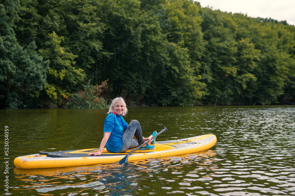 A woman with an oar. A trip on a SAP board. A big river in the middle of the forest, an extreme route. Tours and tourism, active recreation. fun