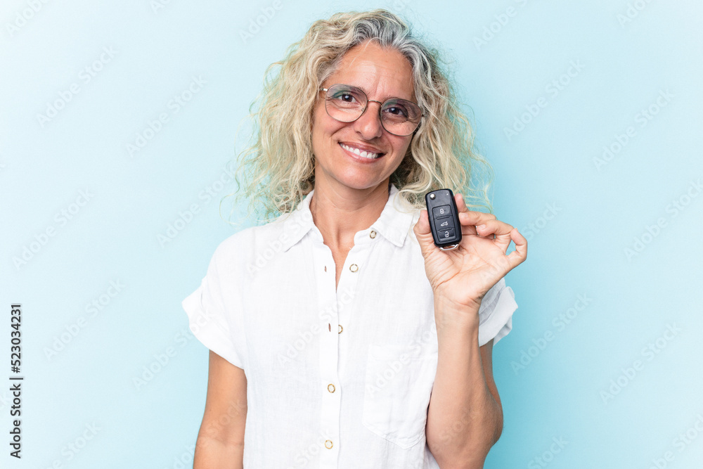 Middle age caucasian woman holding a car keys isolated on blue background happy, smiling and cheerful. Middle age caucasian woman holding a car keys isolated on blue background happy, smiling and cheerful.