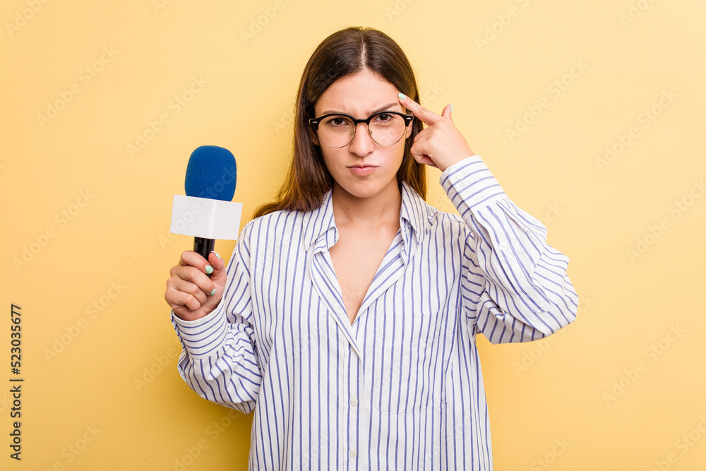 Young caucasian presenter TV woman isolated on yellow background showing a disappointment gesture with forefinger. Young caucasian presenter TV woman isolated on yellow background showing a disappointment gesture with forefinger.