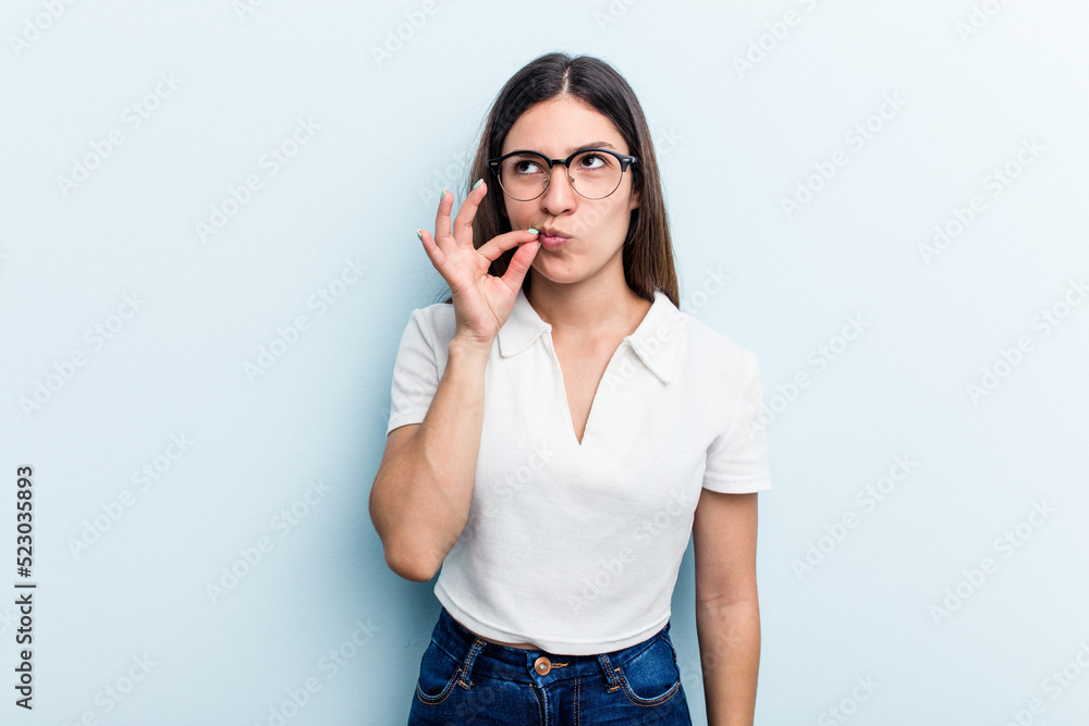 Young caucasian woman isolated on blue background with fingers on lips keeping a secret. Young caucasian woman isolated on blue background with fingers on lips keeping a secret.