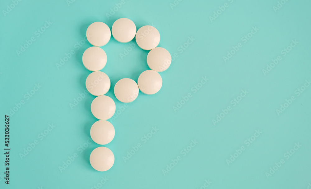 Letter P made from white pills on a blue background. White medical pills. Macro top view with copy space. Health care and pills concept, pharmaceutical, disease prevention Letter P made from white pills on a blue background. White medical pills. Macro top view with copy space. Health care and pills concept, pharmaceutical, disease prevention