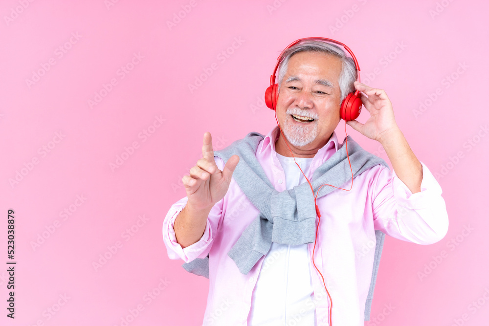senior old man smile wearing red headphones, happiness asian old man listen music dance pink background. senior old man smile wearing red headphones, happiness asian old man listen music dance pink background.