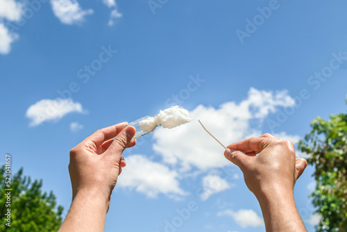 A piece of cotton wool against the sky. Picking up clouds with your hands in a glass dish.