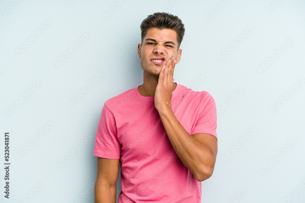 Young caucasian man isolated on blue background having a strong teeth pain, molar ache. Young caucasian man isolated on blue background having a strong teeth pain, molar ache.