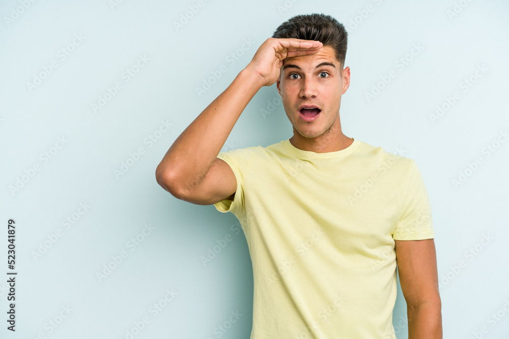 Young caucasian man isolated on blue background shouts loud, keeps eyes opened and hands tense. Young caucasian man isolated on blue background shouts loud, keeps eyes opened and hands tense.
