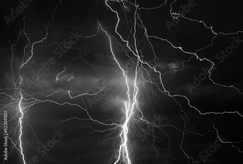 Fork lightning striking down during summer storm in black and white