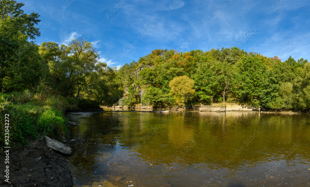 landscape river in valley with forest and rocks on the shore