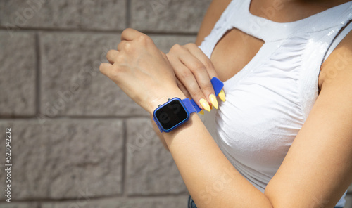 Woman wearing blue smart watch.
