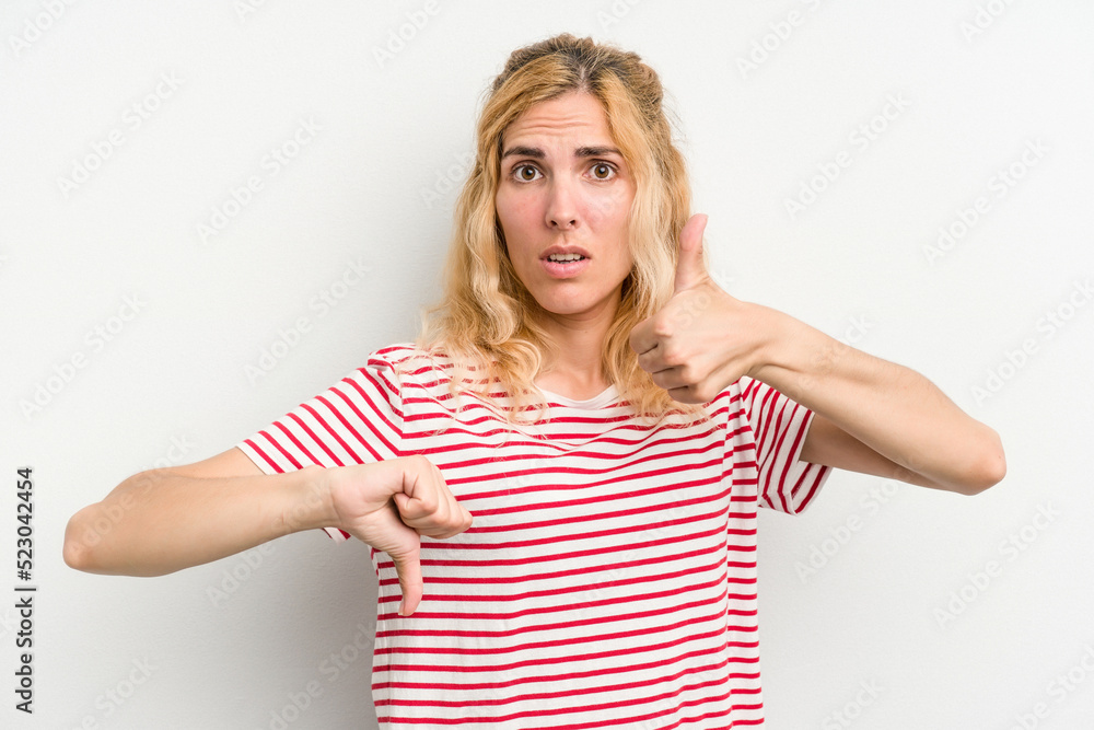Young caucasian woman isolated on white background showing thumbs up and thumbs down, difficult choose concept Young caucasian woman isolated on white background showing thumbs up and thumbs down, difficult choose concept
