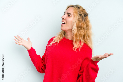 Young caucasian woman isolated on blue background joyful laughing a lot. Happiness concept.