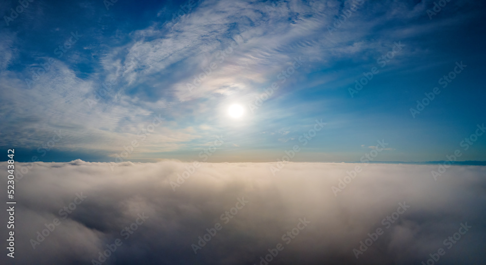 Aerial view from above of white puffy clouds in bright sunny day