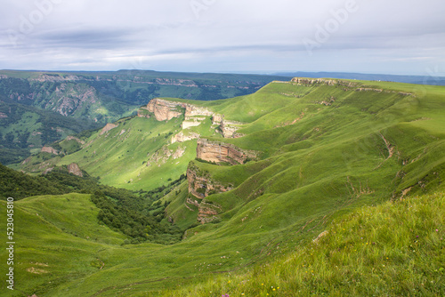 Beautiful landscape - panoramic view of green mountains and hills blurred in morning haze from bermamyt plateau in karachay-cherkessia Russia and copy space photo