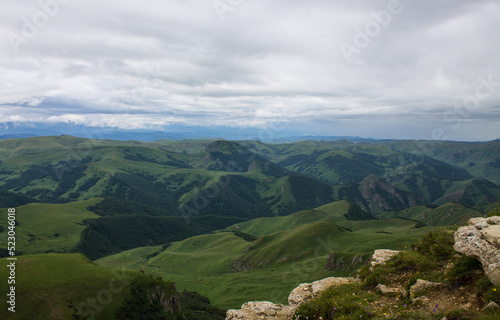 Beautiful landscape - panoramic view of green mountains and hills blurred in morning haze from bermamyt plateau in karachay-cherkessia Russia and copy space