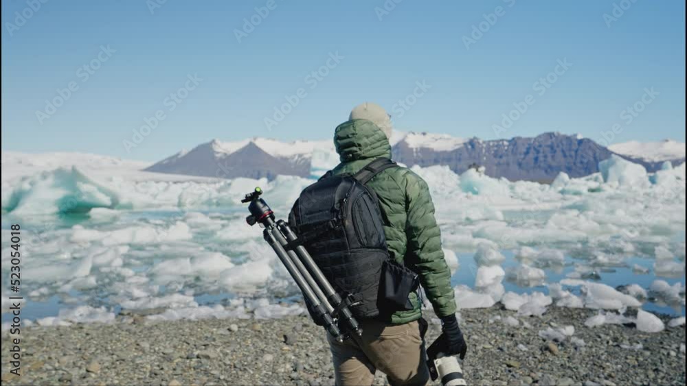 Man Photographer with Backpack Walks Towards Jokulsarlon Glacier Lagoon Iceland Man Photographer with Backpack Walks Towards Jokulsarlon Glacier Lagoon Iceland