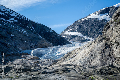 Part of the Nigardsbreen glacier surrounded by high snow capped mountains