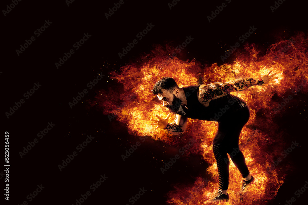 Sporty young man running on fire background