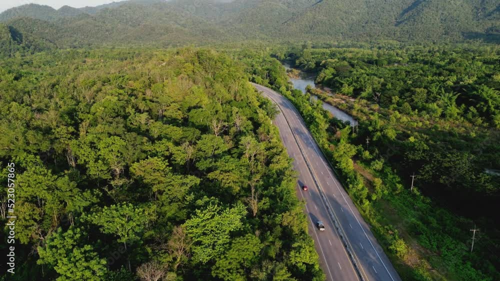 4K Video aerial shot of road riding along road in green forest. Concept for country transportation and sustainable. 4K Video aerial shot of road riding along road in green forest. Concept for country transportation and sustainable.