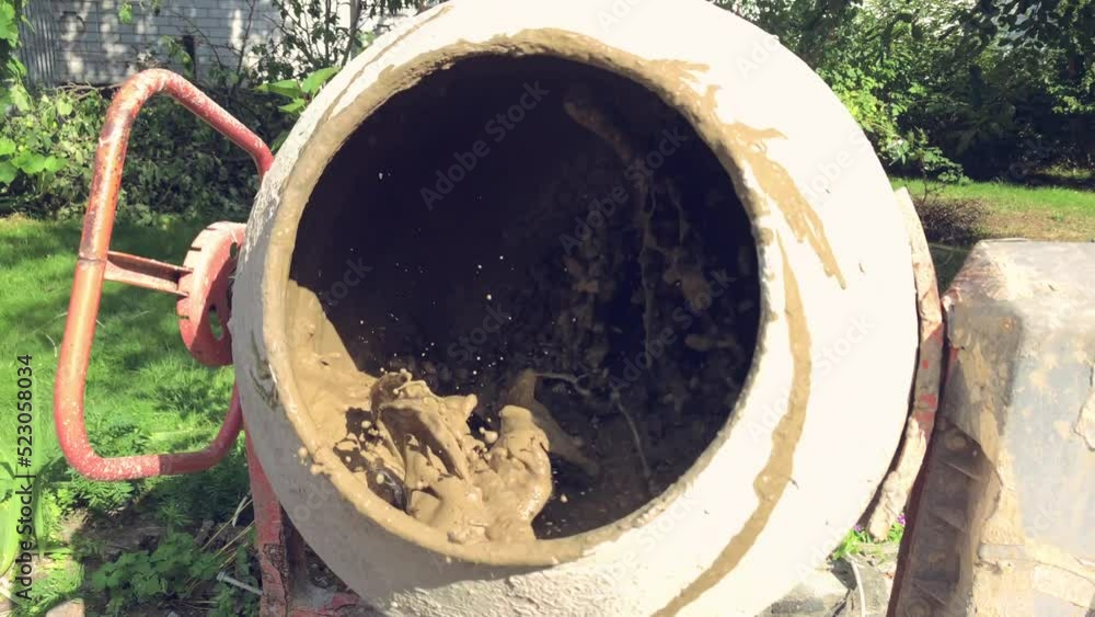 Concrete and crushed stone are mixed in a concrete mixer. Construction work Concrete and crushed stone are mixed in a concrete mixer. Construction work