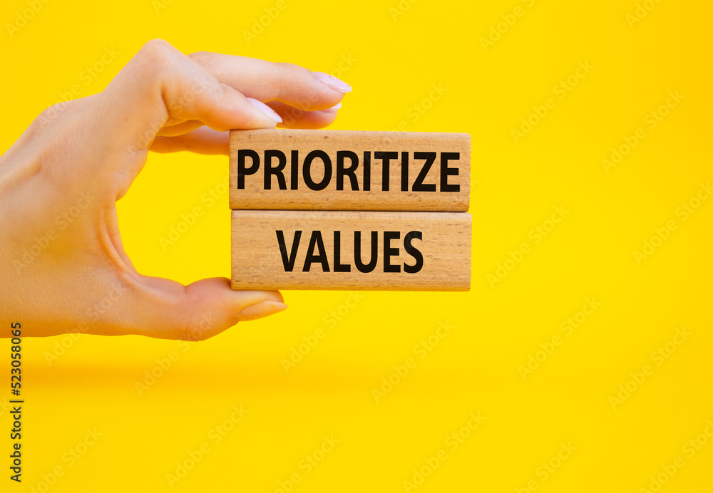 Prioritize values symbol. Concept word Prioritize values on wooden blocks. Beautiful yellow background. Businessman hand. Business and Prioritize values concept. Copy space Prioritize values symbol. Concept word Prioritize values on wooden blocks. Beautiful yellow background. Businessman hand. Business and Prioritize values concept. Copy space