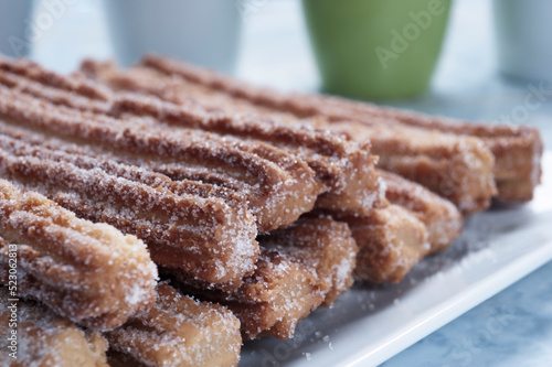 Nahaufnahme von süßen Churros. Ein sternförmiger frittierter Krapfen, welcher traditionell mit Zuckker oder Zimt angerichtet wird - Süße Churros photo