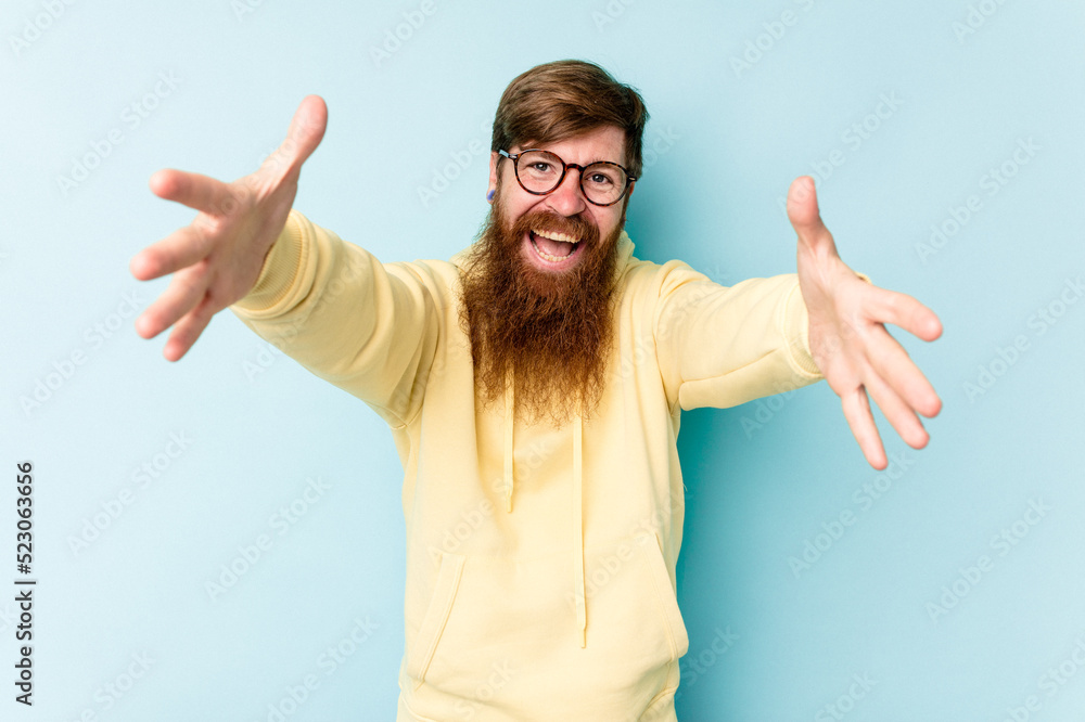 Young caucasian red-haired man isolated on blue background celebrating a victory or success, he is surprised and shocked. Young caucasian red-haired man isolated on blue background celebrating a victory or success, he is surprised and shocked.