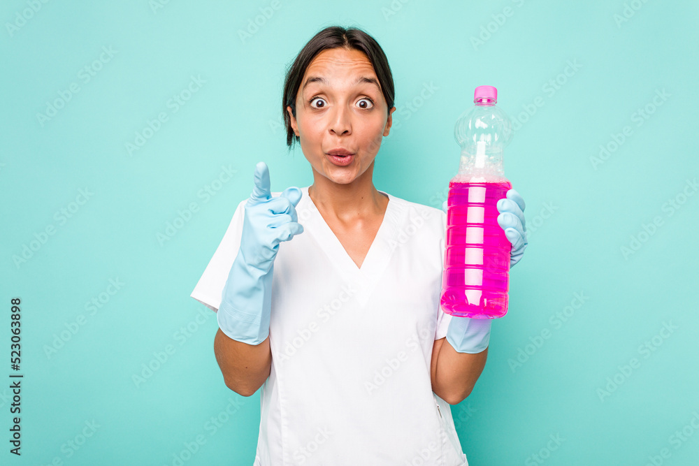 Young cleaner hispanic woman isolated on blue background having an idea, inspiration concept. Young cleaner hispanic woman isolated on blue background having an idea, inspiration concept.