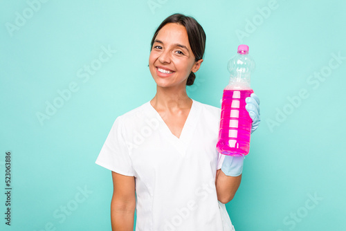 Young cleaner hispanic woman isolated on blue background happy, smiling and cheerful.