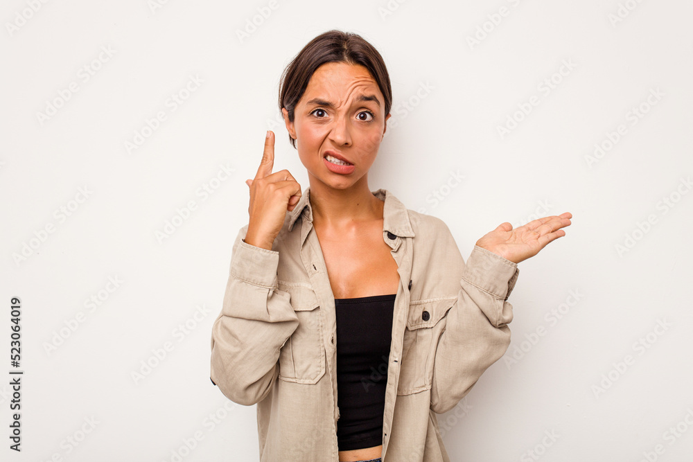 Young hispanic woman isolated on white background holding and showing a product on hand. Young hispanic woman isolated on white background holding and showing a product on hand.
