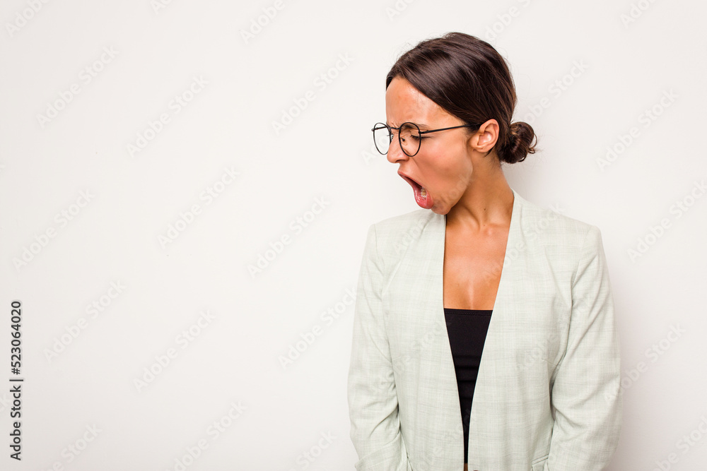 Young hispanic woman isolated on white background shouting very angry, rage concept, frustrated.