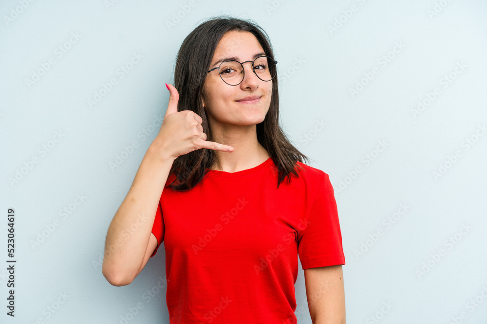 Young caucasian woman isolated on blue background showing a mobile phone call gesture with fingers. Young caucasian woman isolated on blue background showing a mobile phone call gesture with fingers.
